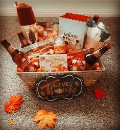 a basket filled with beer and snacks on top of a carpet next to an orange leaf