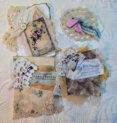 several pieces of fabric and lace are laid out on a bed sheet, with tags attached to them