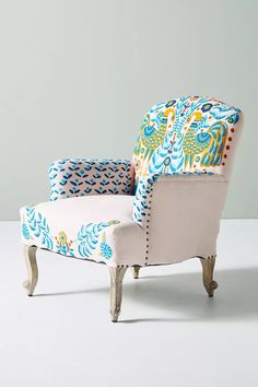 an upholstered chair with blue and yellow designs on the back, against a white background