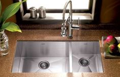 a kitchen sink with two faucets in it