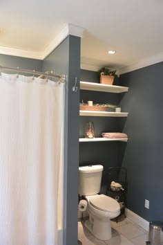 a white toilet sitting in a bathroom next to a bath tub under a shower curtain