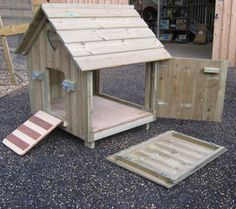 a dog house made out of pallet wood and other items sitting on the ground