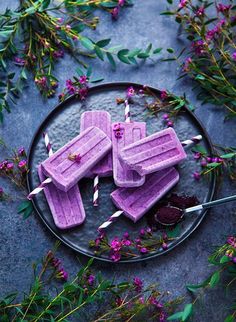 purple popsicles on a plate with flowers and candles