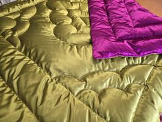 two different colored bedspreads laying on top of each other