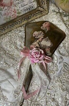 a pink rose sitting on top of a table next to a mirror and framed pictures