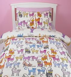 a bed with colorful cats on it in a pink room