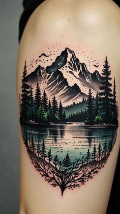 a woman's thigh with a mountain scene tattoo on it