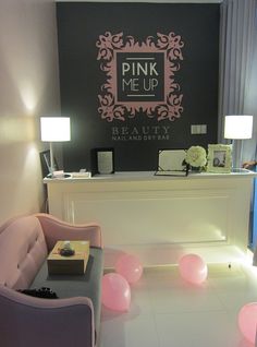 the reception room is decorated with pink balloons and white furniture, along with a chalkboard sign that says pink me up