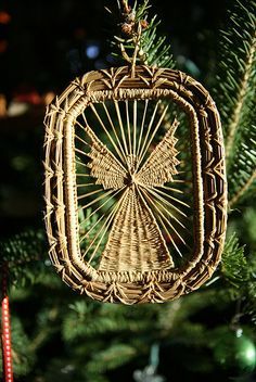 a wicker ornament hanging from a christmas tree