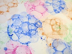 an art project with watercolors on paper and colored paint splattered over it