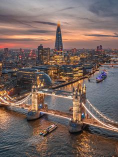 an aerial view of the london skyline at dusk with tower bridge in foreground and other buildings