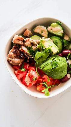 a white bowl filled with vegetables and meat