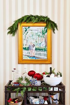 a painting hanging on the wall above a table filled with plates and bowls full of food