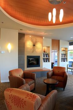 a living room filled with furniture and a fire place in the middle of it's wall