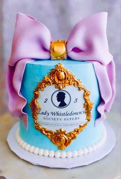 a blue cake with a pink bow on it's top that says lady whistletown's