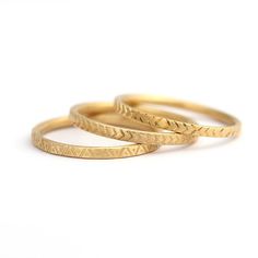 three gold wedding rings on a white background