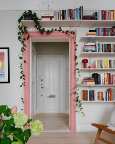 a room with bookshelves filled with lots of books next to a white door