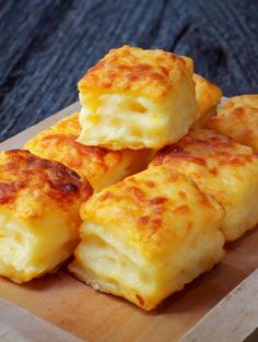 four cheesy biscuits on a wooden cutting board