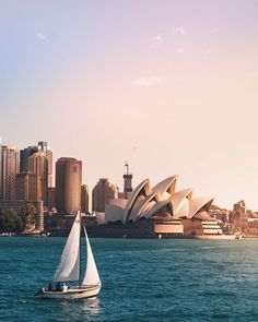 a sailboat in the water with sydney opera house and city skyline in the background