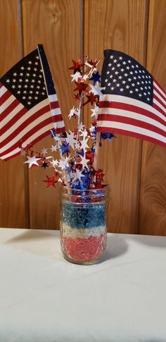 an american flag centerpiece in a mason jar with red, white and blue stars