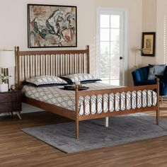 a bed sitting on top of a wooden floor next to a blue chair