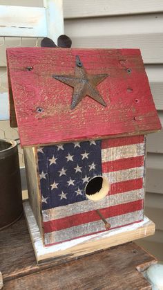 a birdhouse with an american flag painted on it's side and a star in the roof