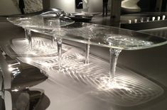 a table that has been made out of glass and is sitting on the floor in front of a mirror