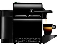 an espresso machine with a cup of coffee next to it on a white background