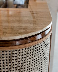 a close up of a wooden table top with perfored metal and wood trim