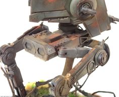 a close up of an action figure made out of metal and wood with a camera attached to it