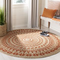 a living room area with a rug on the floor and a plant in front of it