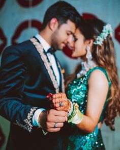 a man and woman are dressed in green outfits, holding each other's hands