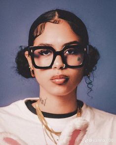 a woman wearing glasses and a white t - shirt with the word love on it