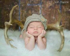 a newborn baby wearing a knit deer antlers hat