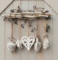 an assortment of ornaments hanging from a wooden frame on a wall in front of a barn