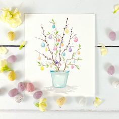 an easter card with flowers in a pot and eggs scattered around it on a white surface