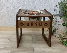 a wooden table with a dog paw print on it and a bowl of food in the middle