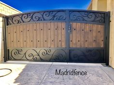 an iron and wood gate with the words matrifience on it in front of a house