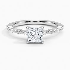 a princess cut diamond engagement ring with diamonds on the band