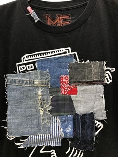 a black t - shirt with different colored patches on it