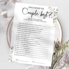 a couple's best question card sitting on top of a plate next to flowers