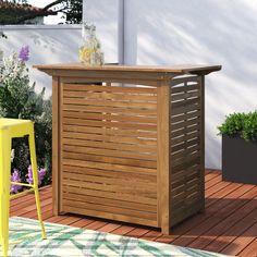 a wooden bar on a deck next to a yellow stool