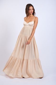 Make a big impact in the Blaire Nude Satin Tiered Maxi Dress! This black-tie wedding must checks all the boxes. Satin fabric form a cami strap maxi dress with a tiered A-line skirt and a bold corset top. Style with some gold jewelry and strappy heels for a formal night out. DETAILS & FIT Fit-and-Flare. Polyester Dry clean for best results. Imported. Satin Boho Dress, Maxi Dress A Line, Granola Prom Dress, Nude Bridesmaid Dress, Neutral Dresses Formal, Summer Flowy Maxi Dress, Summer Indian Wedding Outfit, Wedding Guest Dress Corset, Neutral Maxi Dress