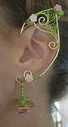 a close up of a person's ear with flowers and leaves attached to it