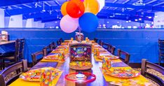 a table set for a birthday party with balloons