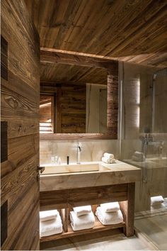 a bathroom with wooden walls and white towels