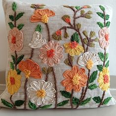 an embroidered pillow with flowers on it