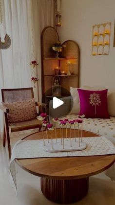 a living room filled with furniture and flowers on top of a coffee table in front of a window