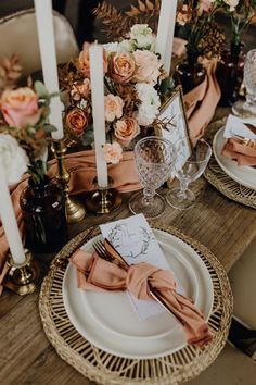 the table is set with candles, plates and napkins