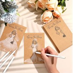 the bride's dress is drawn on two notebooks with pencils next to it